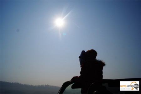 Geschützt durch die Schweißermaske blickt Sophie auf die partielle Sonnenfinsternis, die mit bloßem Auge nicht zu sehen ist....weil das restliche Sonnenlicht noch grell genug ist, um den Augen gefährlich zu werden. Foto. v. Gallera