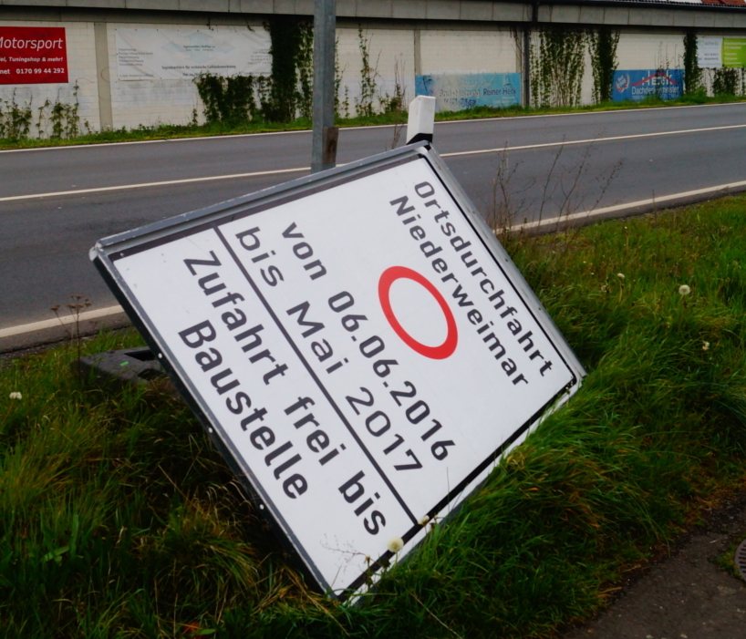 Die Hinweistafel, die über Bauzeit informiert, liegt schon am Boden. Doch die Arbeiten verzögern sich noch um "sechs bis acht Wochen"..Foto: v. Gallera