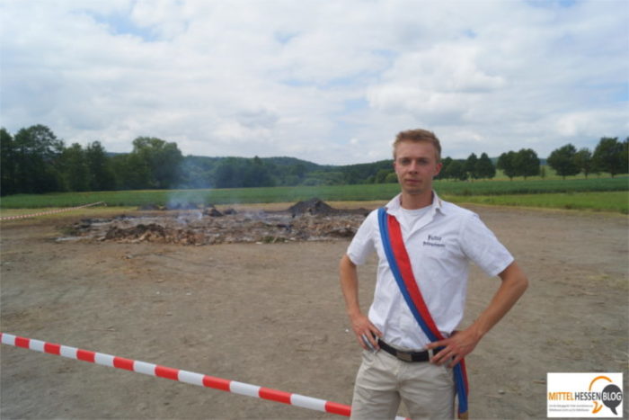 Felix Hartmann, Vorstandsmitglied der Fellinghäuser Burschen- und Mädchenschaft, vor der Absperrung des abgebrannten Sonnwendfeuers. Foto: v. Gallera